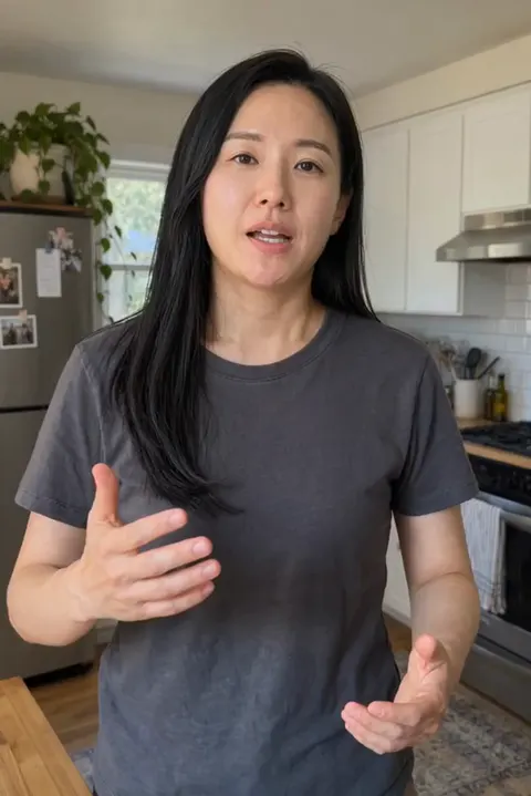 Actual Aisma result: The same explanation performed by a fictional East Asian woman about 32, in a charcoal T-shirt.